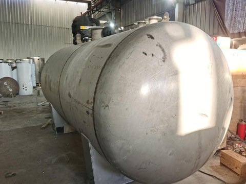 Factory workers are manufacturing stainless steel tanks