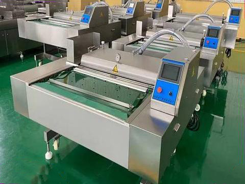 Rolling belt vacuum packaging machine feeding pouches on a conveyor for continuous high volume packing