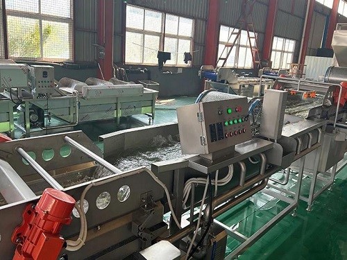 Side view of a stainless steel eddy current cleaning machine showing the vortex tank and vibration conveyor